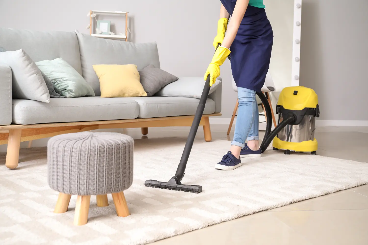 Männliche Umzugshelfer wickeln Sofa im Zimmer mit Stretchfolie ein, Nahaufnahme